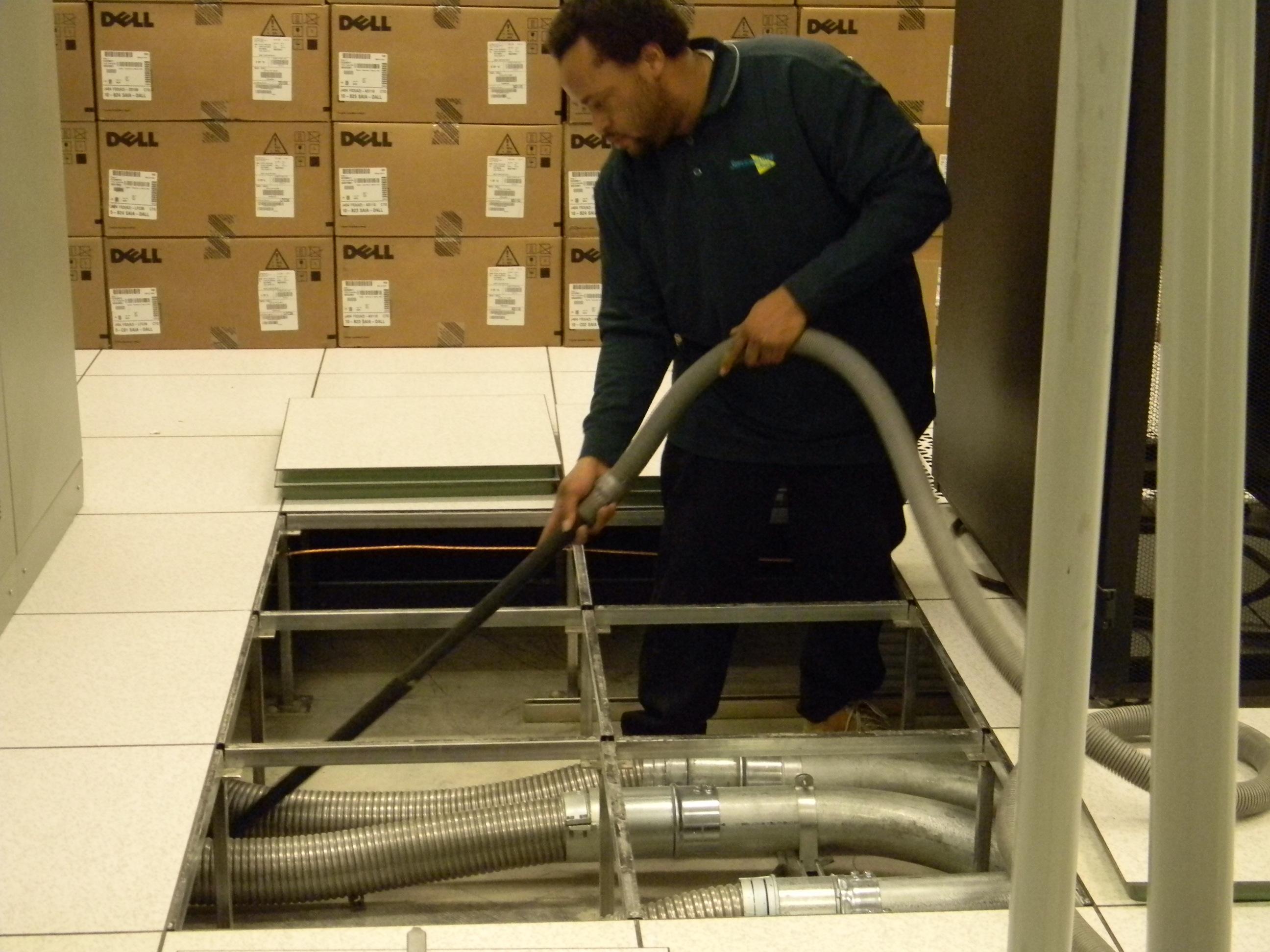 A crew member doing computer room cleaning