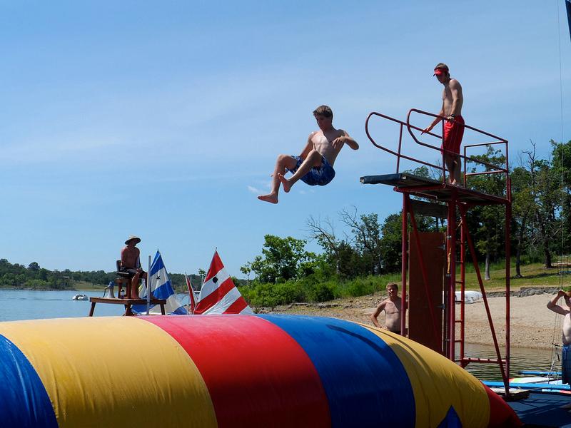 Campers jumping on the blob at the lake