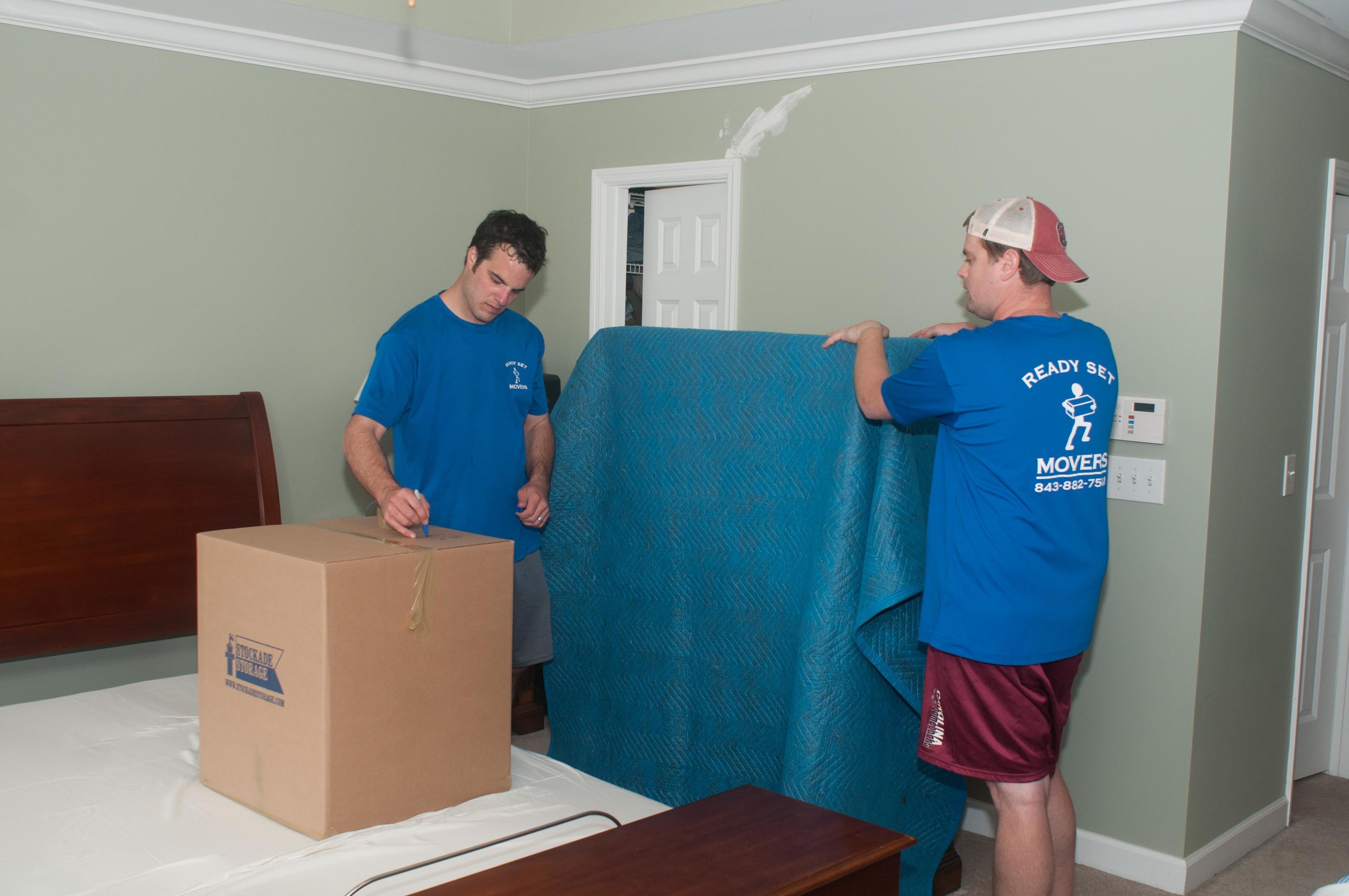 Ready Set Movers crew wrapping up a dresser with a heavy duty furniture pad.