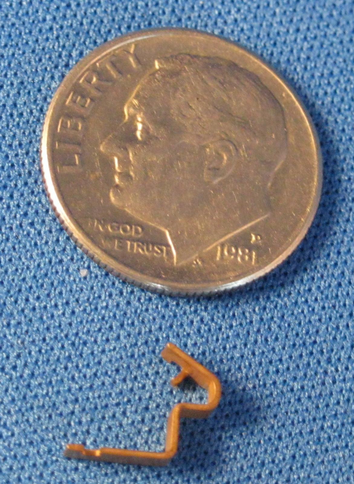 Small metal part compared to dime