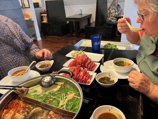 Hot Pot!!! With beef, lamb, noodles, wontons, spinach, and all three dipping sauces.