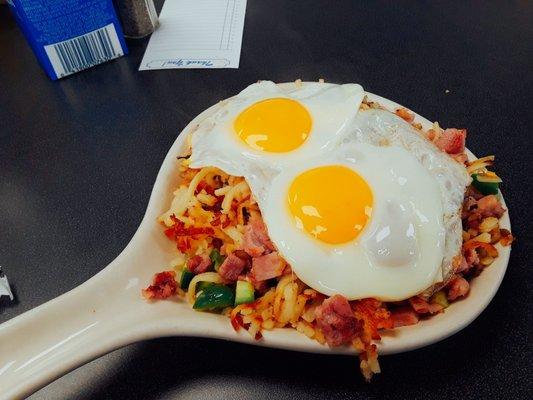 The hobo skillet with added jalapeñoes ($6.50). Topped with two eggs sunny side, it has plenty of hash browns, onions, ham and cheese!