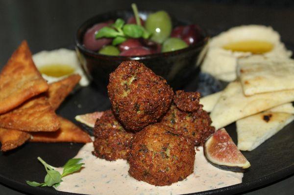 The Mezze Plate was made with pepper spread, hummus, tzatziki, baba ghanoush, falafel, olives, figs, and flatbread two ways.