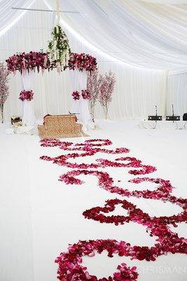 Sikh ceremony decor with a round structure. Draped in flowers.