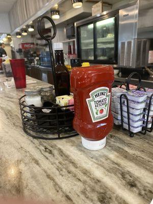 Condiments at the counter. Pie in the back.