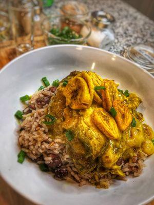 Coconut milk curry chicken with rice and peas. Topped with fried plantains.