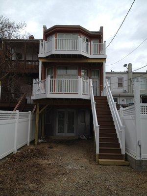 Two-level vinyl deck and vinyl privacy fence