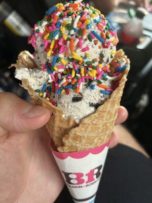 Waffle cone with Oreo cookie ice cream and rainbow sprinkles