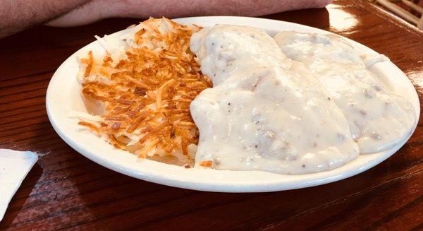 Large biscuits and gravy with hash browns.