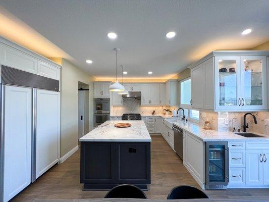 Kitchen remodel in San Diego with quartz countertops and backsplash and white cabinets.