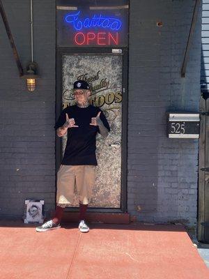 Justin in front of the shop door.