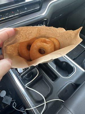 1/2 dozen glazed donuts in a a paper bag.