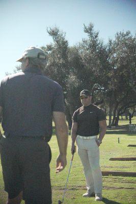 Coach Charlie Crenshaw coaching a new golf student.