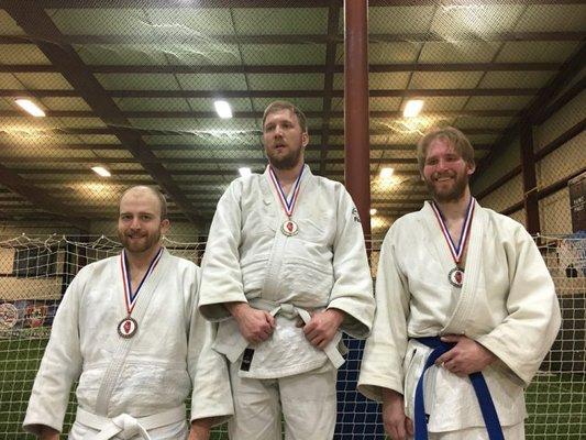 First principles judo student taking gold at a competition