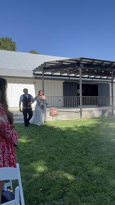 Bride walking down the aisle. Might want to go barefoot or your heels will sink into the damp grass.