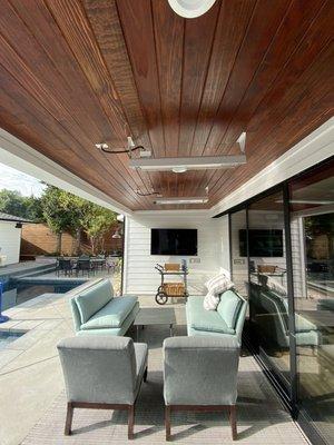 Renovated backyard seating area with new wall panels. Re-wired for custom wall and ceiling outlets installed for the tv and heater.