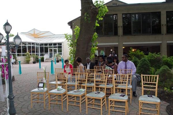 Staff setting up outdoor area for ceremony and to the left was an outdoor cocktail hour following ceremony