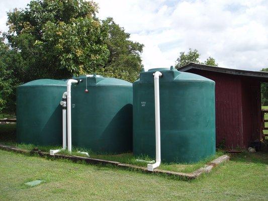 Hybrid rainwater harvesting and well water storage system with three 2,500 gallon polyethylene cisterns