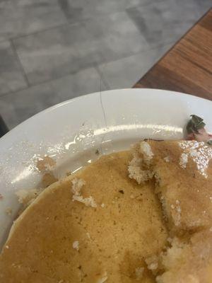 HAIR moved to the side of the plate. Very long hair because the rest was still under the pancake.