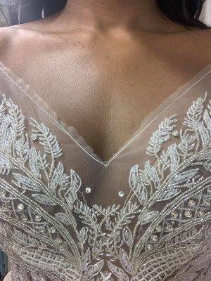 The terrible neckline she did and the two rhinestones to cover the tears she created in the illusion mesh.