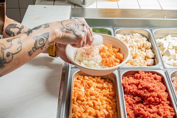 Fresh Sushi Grade Goodness!  Watch as our skilled staff scoops the finest ingredients into every bowl, ensuring a deliciously vibrant.