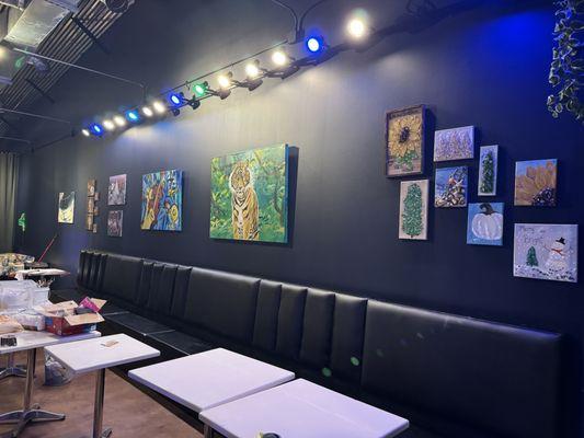 Local artists on display for sell and comfortable booth seating to sit, sip, and paint stenciled canvas