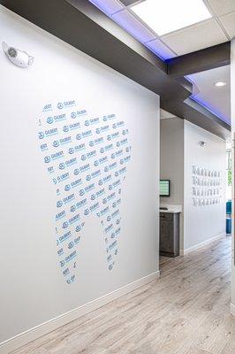 This is our photo wall. When our patients finish braces they get to take a photo in front of the tooth logo!