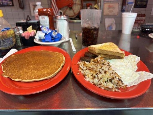 Three eggs over easy with hash browns, sausage and a pancake !