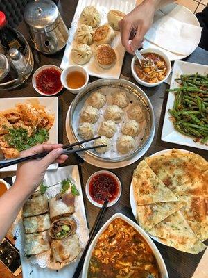 Soup dumplings, beef rolls, spicy wontons, scallion pancakes, sweet and sour soup, sautéed green beans and meat and veggie pan fried buns