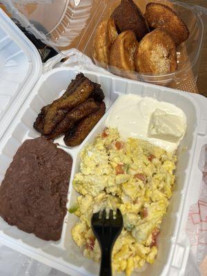 Scrambled eggs, refried beans, plantains, sour cream and cheese. Off to the side are traditional quesadillas.