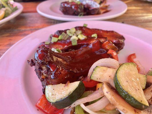 St. Louis baby back ribs half served two plates with fresh mixed veggies