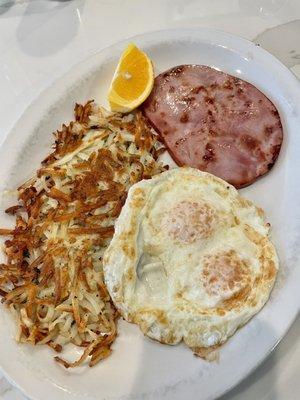 Two eggs over easy, ham steak and hash browns