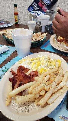 Scrambled eggs, bacon, fries, coffee.