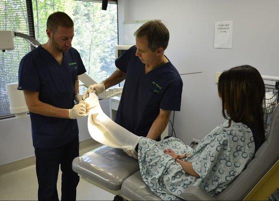 Podiatrists Timothy Young and Brandon Nelson working with a patient