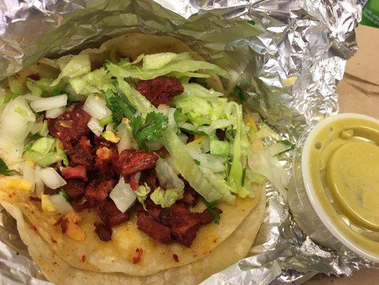 Al pastor on corn tortilla , onion , cilantro, lettuce