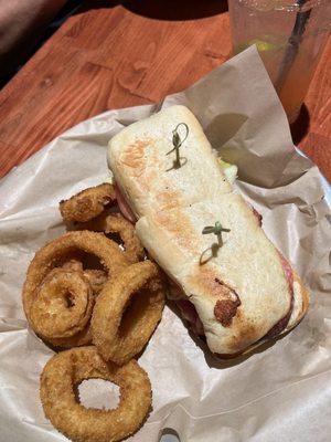 Italian sandwich with six onion rings.