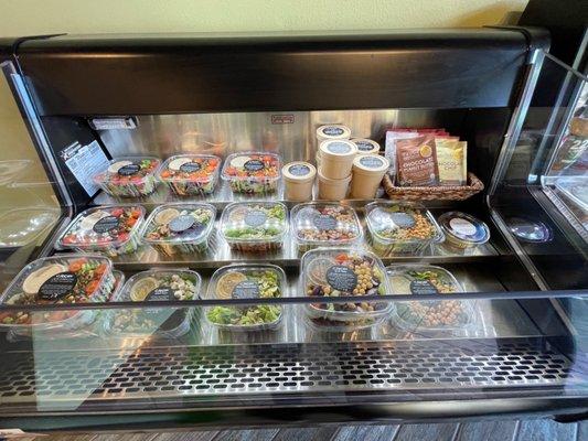 A refrigerator full of salads and soups