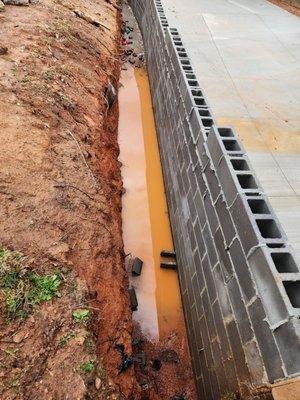 Incomplete retaining wall without proper drainage