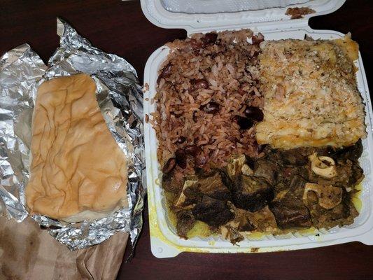 Large Curry goat with peas and rice and baked mac and cheese with Coco bread.