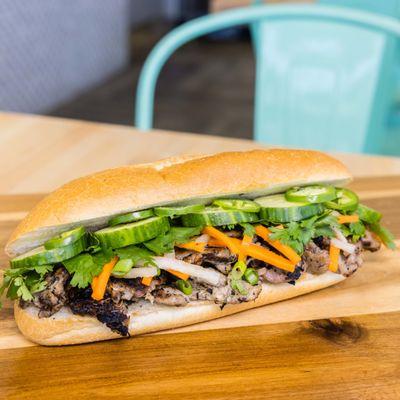 Pork Bánh Mì. Grilled lemon grass pork, pickled carrot & daikon, jalapeno, cucumber, cilantro herb mix, scallion, mayo on classic bread