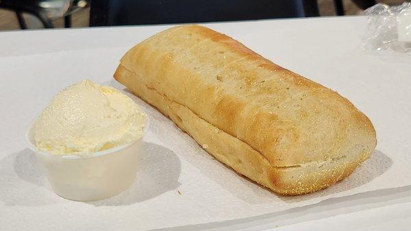 Hoagie size loaf of bread with very fluffy whipped butter.