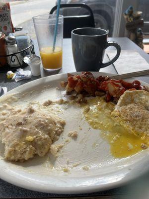 Biscuits with sausage, gravy, home fries, and a fried egg, a decent sized cup of coffee and a large orange juice