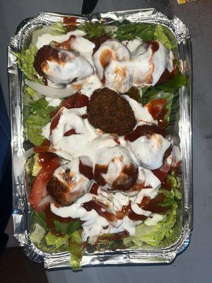 Falafel platter with lettuce, topped with garlic and spicy sauces