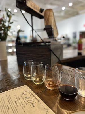 Wine flight with artisanal raclette in the background.