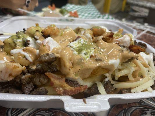 SuperChon Fries french fries with bacon, shrimp, cheese, sour cream, special sauce, guacamole and carne asada.... This is a half order of