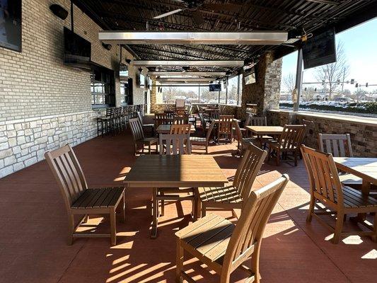 Spacious Patio with a Fireplace and Window Access to the Main Bar Inside