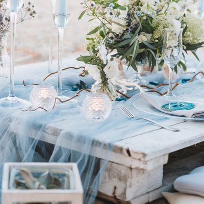 Seaside table scape with simple greenery centerpieces.  #carlsbadflorist #oceansideflorist #sandiegoflorist #carlsbadflowers