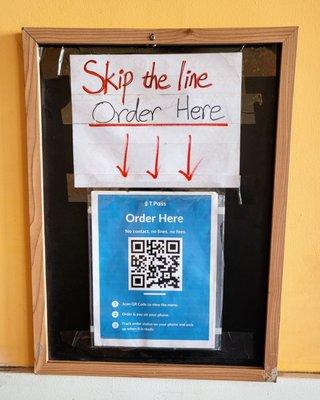 Near front door sign to scan QR code and order ahead.