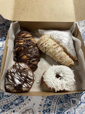 Chocolate croissant, buttercream filled donut pastry, coconut donut, almond croissant, and lemon tart