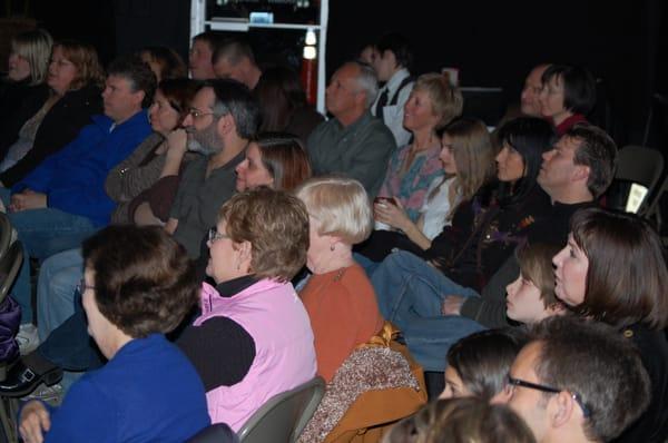 Full house watching an improv comedy show.